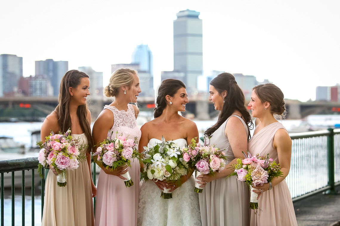 Bridesmaids in front of Royal Sonesta with Charles River and Boston skyline in the background