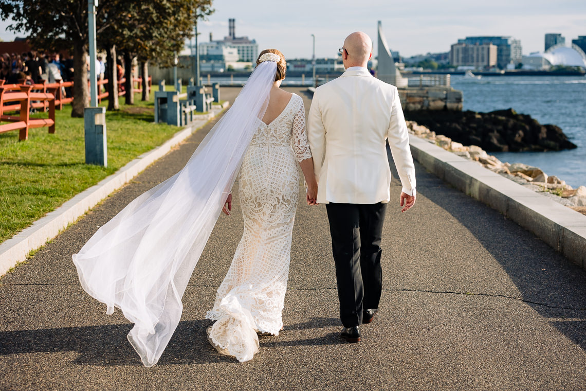 Wedding couple walking on harborwalk at Hyatt Regency Boston Harbor